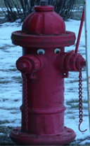 red hydrant with googly eyes with snow on the ground