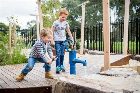 photo of kids playing with outdoor water pump